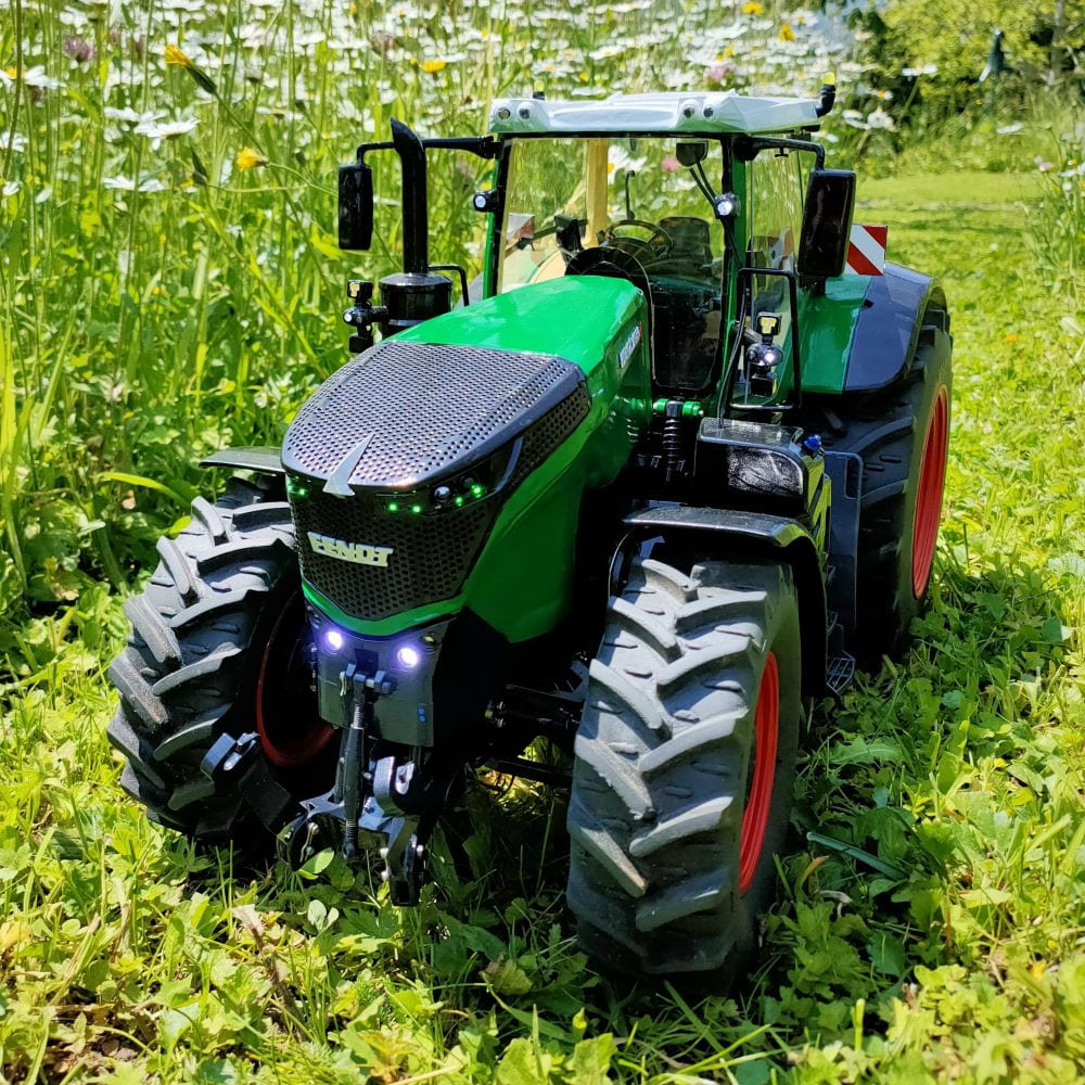 The tractor is moving through the grass